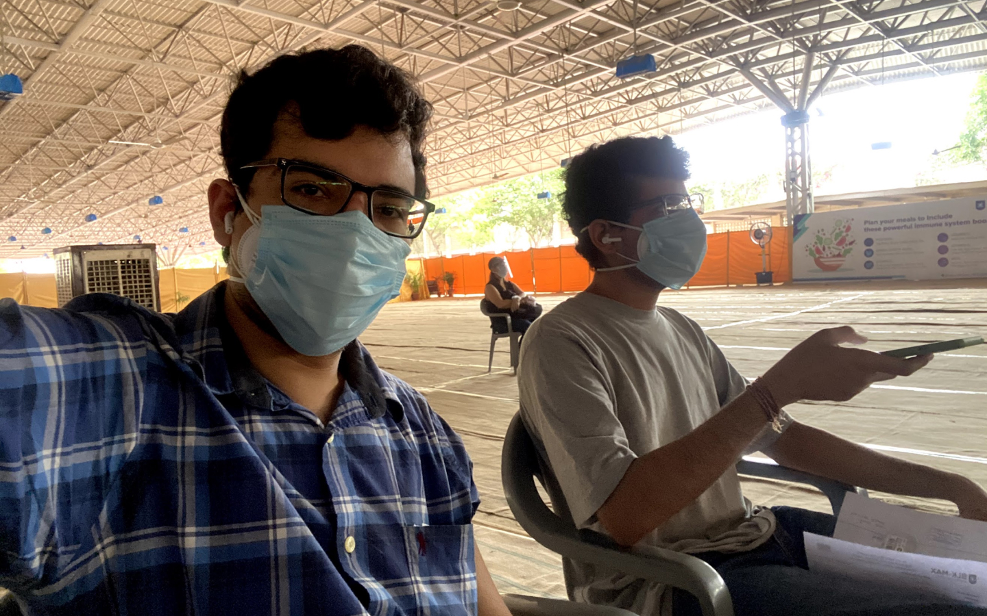 Two people sitting with masks on