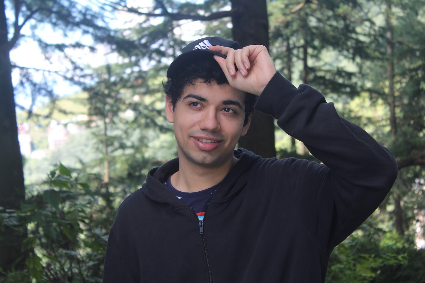 A photo of me wearing a cap, trees in the background