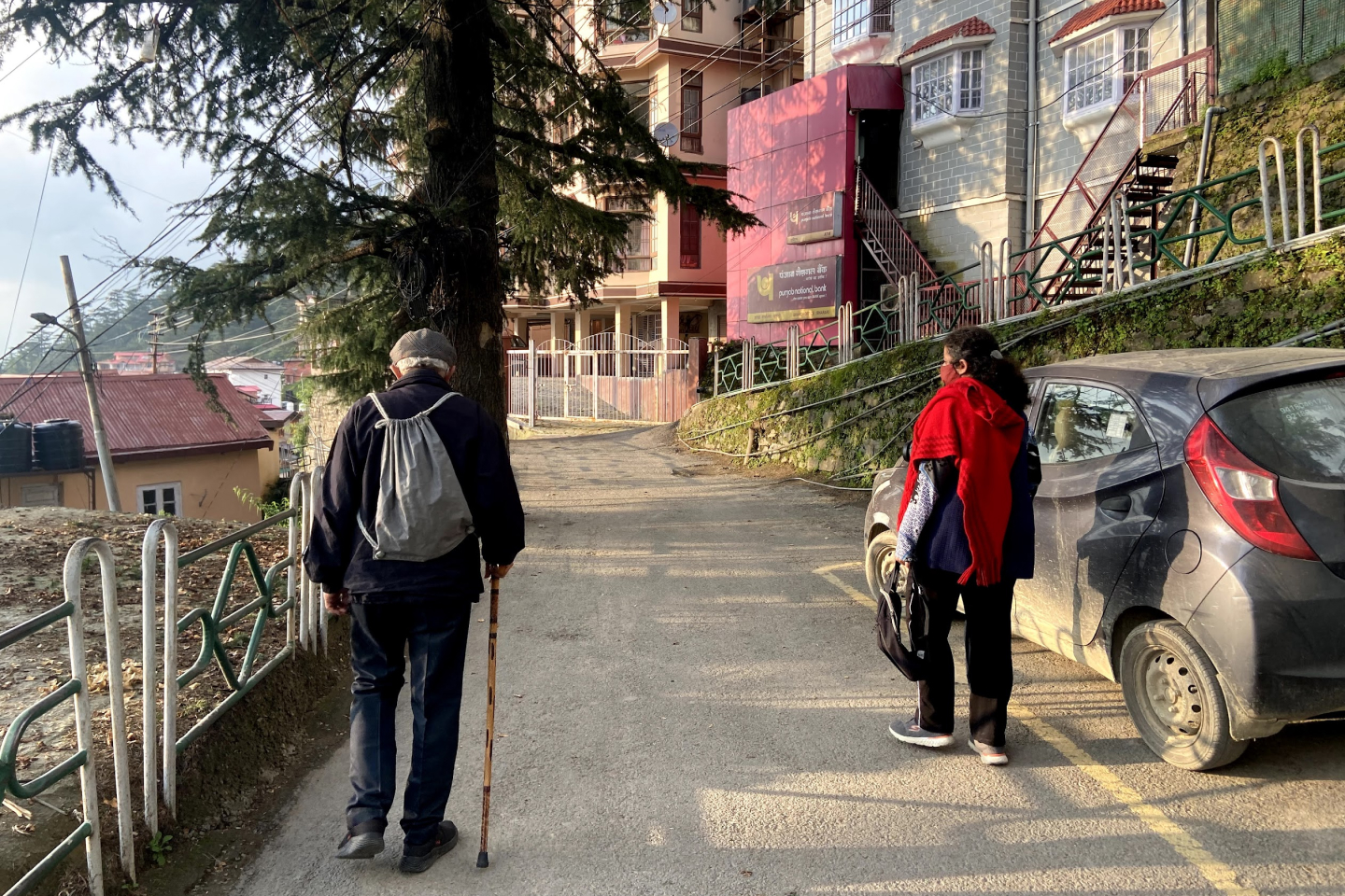 An old man and a woman walking up an incline