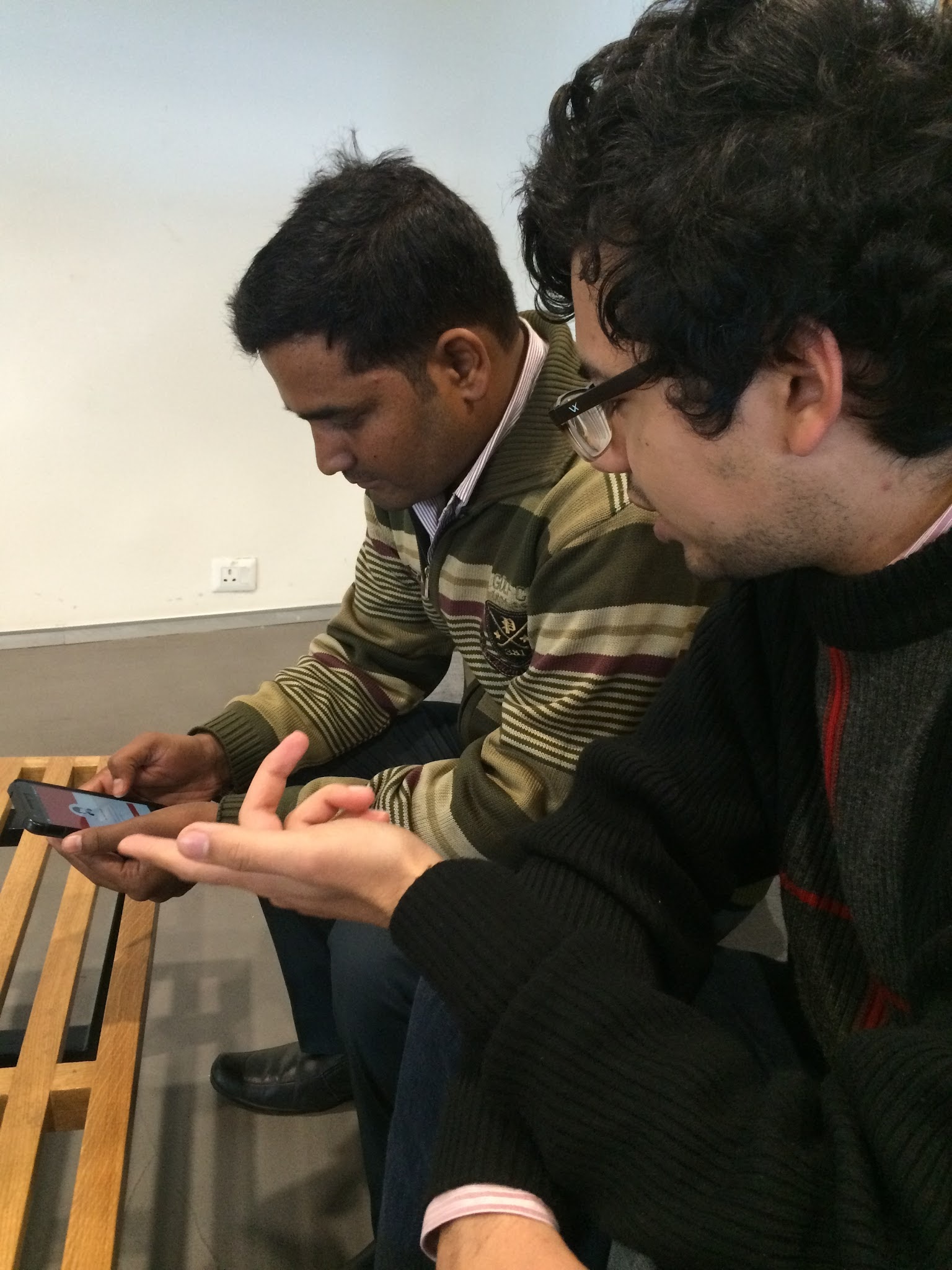 A Zomato employee holding a phone with a prototype of the app.